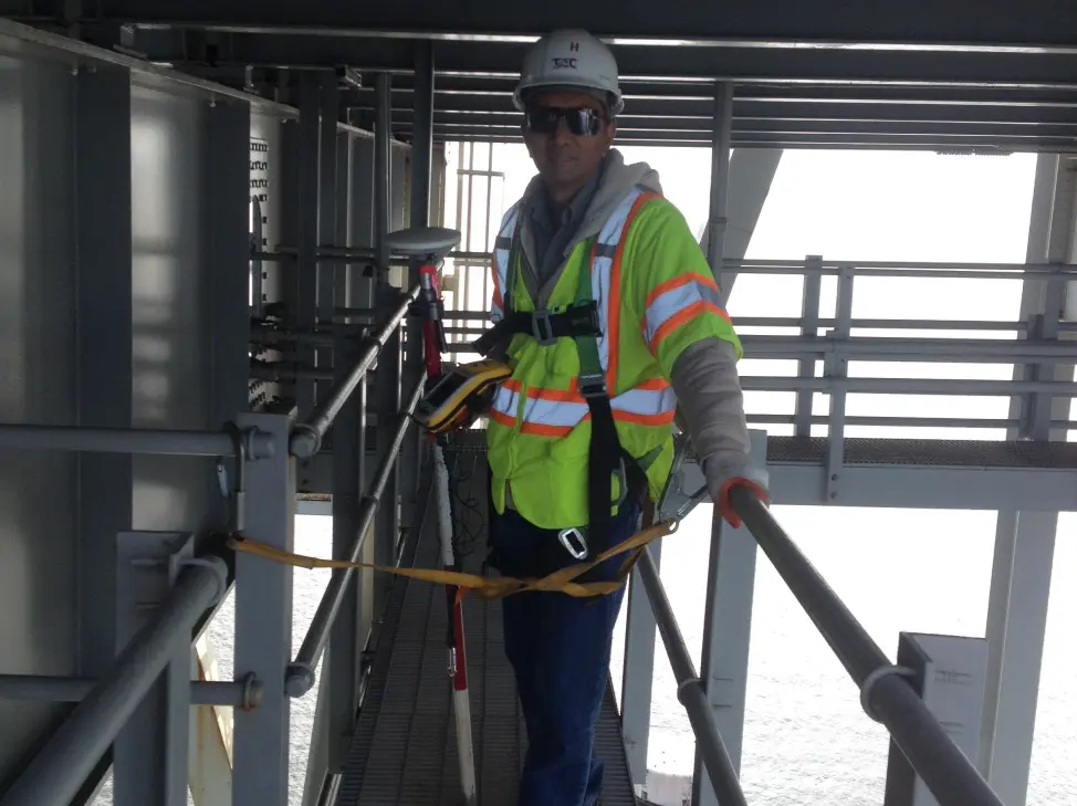 A man in safety gear standing on some steps.